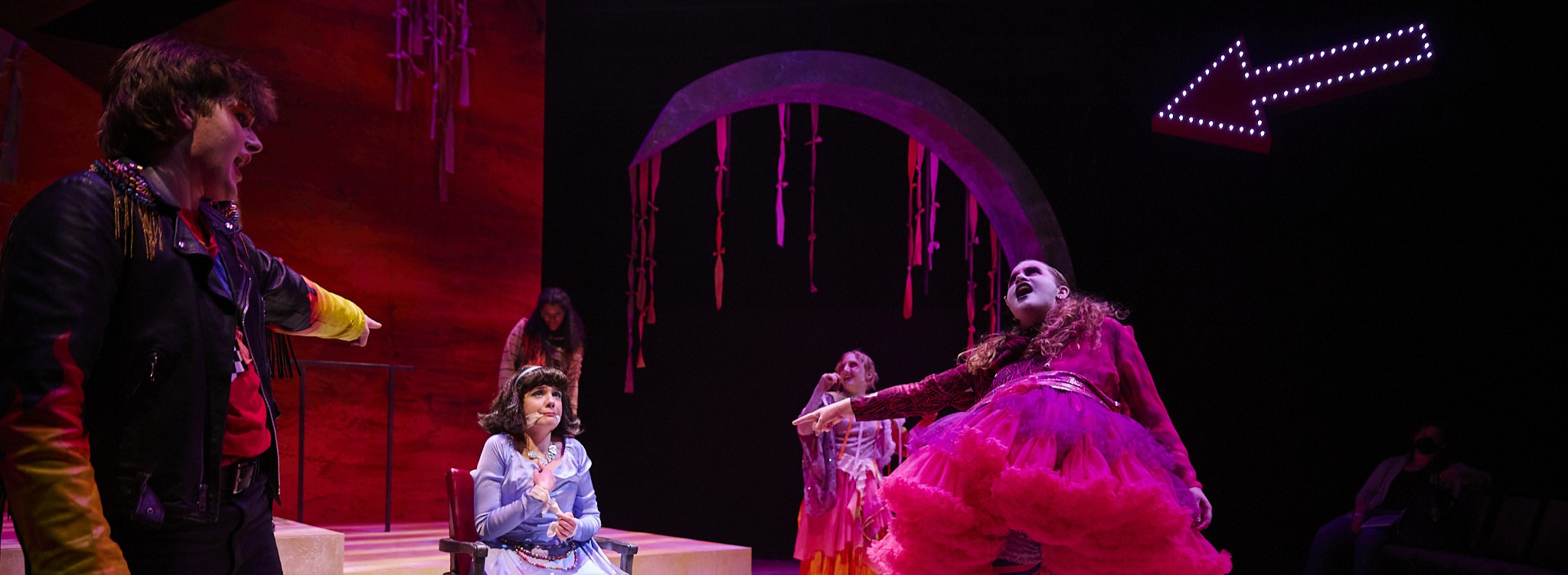 A young person roars with a wide open mouth, surrounded by other young women.